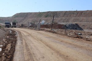 Μετά και τη δημοσιοποίηση της νέας τροποποίησης της Απόφασης Έγκρισης Περιβαλλοντικών Όρων, για ακόμη μεγαλύτερη επέκταση του ΧΥΤΑ, σε νέα φάση αντιπαράθεσης οδηγείται το ζήτημα του ΧΥΤΑ Φυλής, καθώς ο Δήμος Φυλής αποφάσισε να προσφύγει στο Συμβούλιο της Επικρατείας (ΣτΕ) κατά της πρόσφατης απόφασης του Υπουργείου Περιβάλλοντος και Ενέργειας που εγκρίνει καθ’ ύψος επέκταση της εγκατάστασης. Η απόφαση της Δημοτικής Επιτροπής ελήφθη ομόφωνα στις 12 Φεβρουαρίου 2026, ανοίγοντας τον δρόμο για δικαστική σύγκρουση γύρω από το πιο αμφιλεγόμενο έργο διαχείρισης απορριμμάτων της Αττικής. Σύμφωνα με τη δημοτική αρχή όμως, η συγκεκριμένη τροποποίηση ανοίγει τον δρόμο για επιπλέον έργα ταφής απορριμμάτων και αύξηση της συνολικής χωρητικότητας του ΧΥΤΑ κατά περισσότερα από 2 εκατομμύρια κυβικά μέτρα. Στο σκεπτικό της απόφασης, ο Δήμος Φυλής υποστηρίζει ότι η περιοχή έχει ήδη υποστεί δυσανάλογο περιβαλλοντικό βάρος, καθώς εδώ και δεκαετίες συγκεντρώνεται το μεγαλύτερο μέρος των αποβλήτων της Αττικής. Η περαιτέρω αύξηση της δυναμικότητας ταφής, όπως σημειώνεται, αναμένεται να εντείνει τις επιπτώσεις στο φυσικό περιβάλλον, τη δημόσια υγεία και την ποιότητα ζωής των κατοίκων.